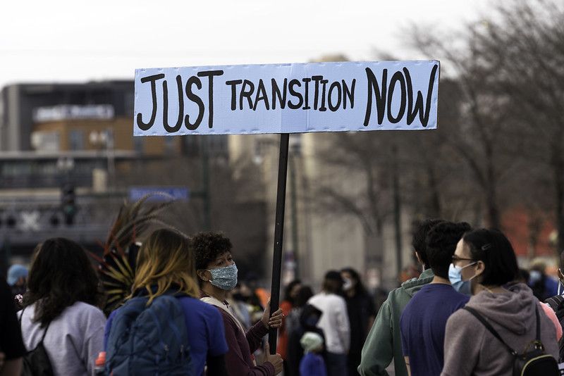A woman holds a Just Transition Now sign at a rally in Minneapolis, Minnesota.